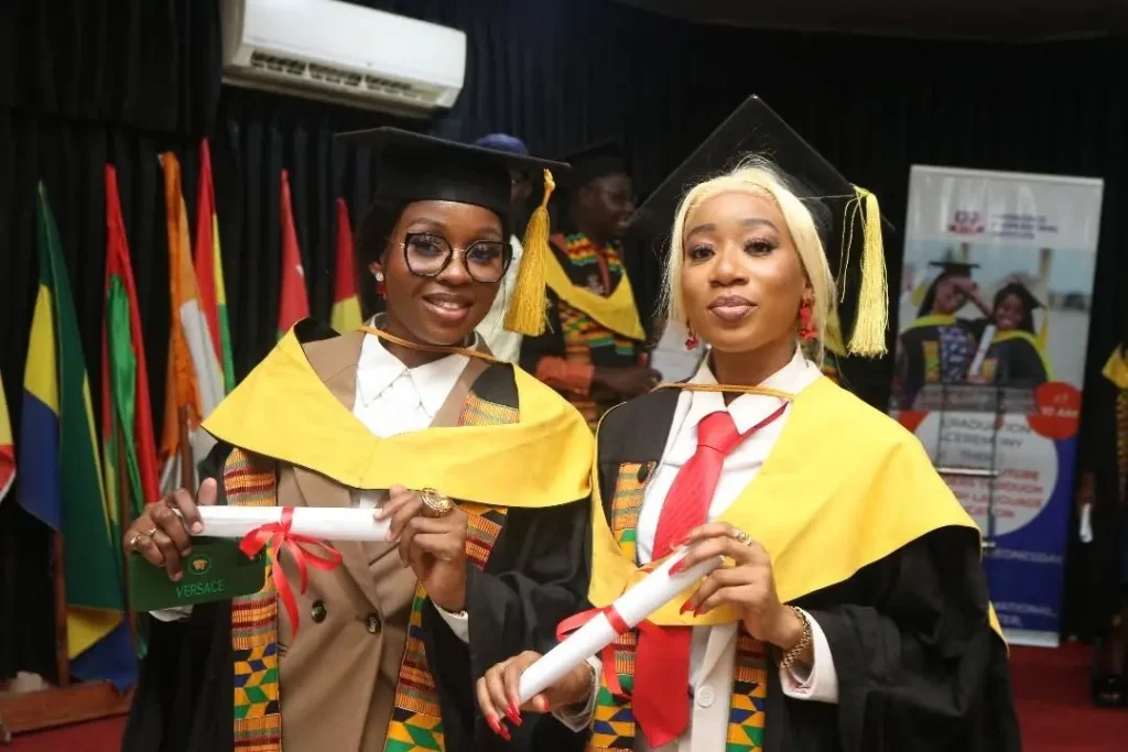 Deux diplômées d'IPI en étole kente tenant leur diplôme