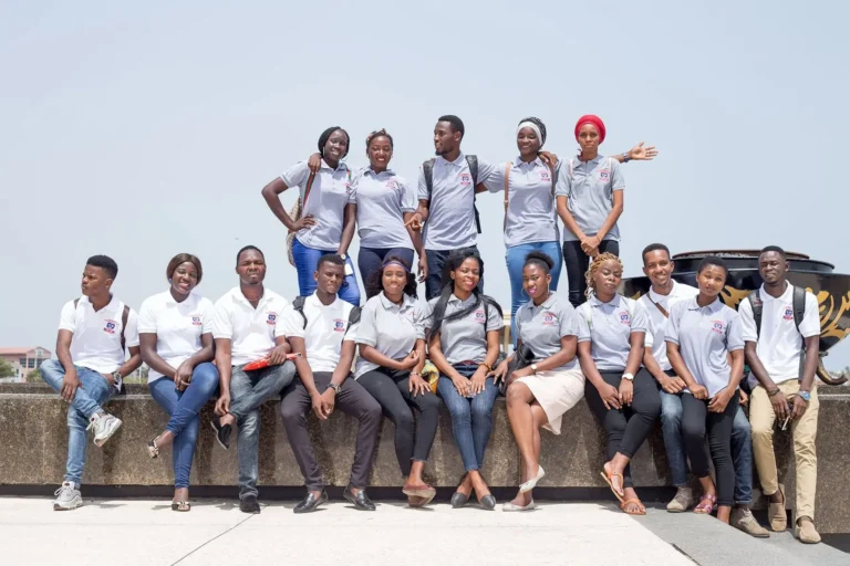 Étudiants d'IPI en t-shirt de l'institut posant ensemble à Accra