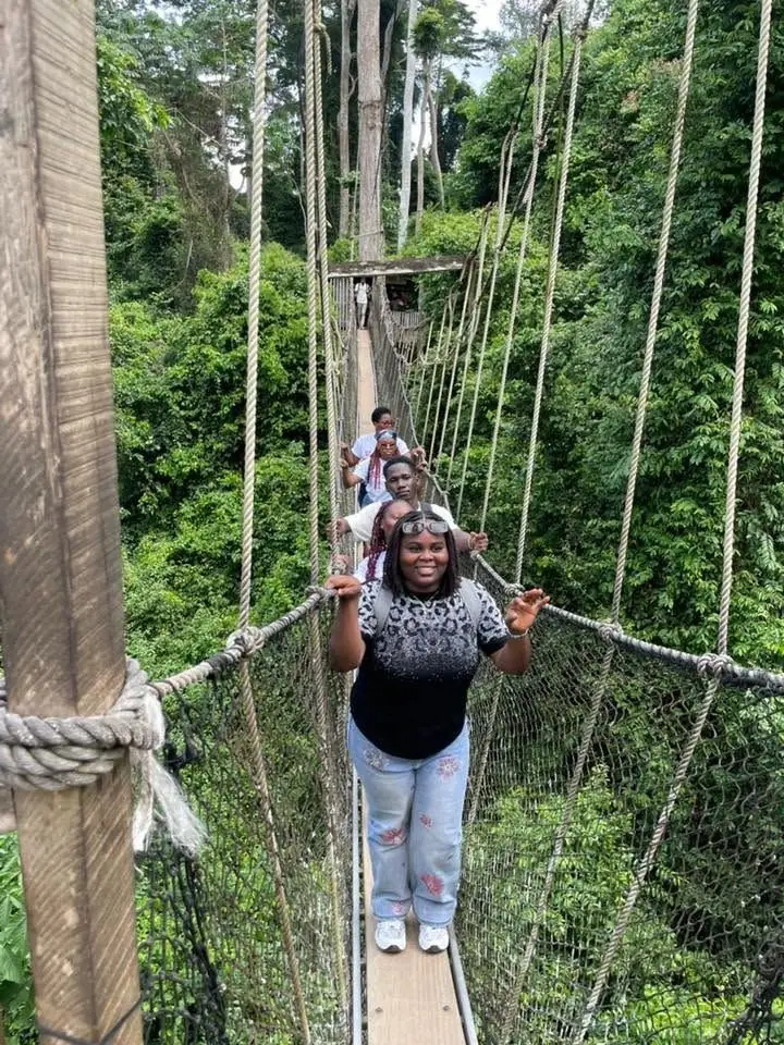 Étudiante d'IPI traversant un pont suspendu en forêt lors d'une excursion