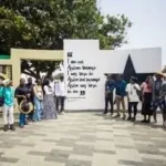 Étudiants d'IPI devant un mur de citations lors d'une sortie culturelle